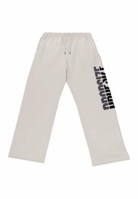 Beige sporta bikses ar auklu viduklī, sānu kabatām un lielu melnu "DROPSIZE" grafiku, kas izdrukāta vertikāli uz kreisās kājas.