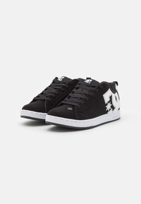 Black sneakers made of synthetic material with white accents, featuring a lace-up design, logo detail on the side, and rubber sole.