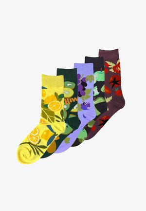 Fem farverige sokker med frugt- og grøntsagsmønstre, herunder citron, kiwi, druer, grøn æble og tomat på forskellige baggrunde.