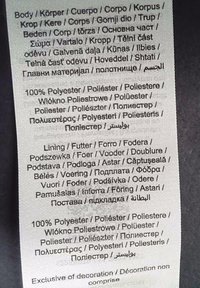 Etichetta di cura in tessuto bianco con testo multicolore in varie lingue, che indica il materiale come 100% poliestere e dettagliando i componenti come la fodera.