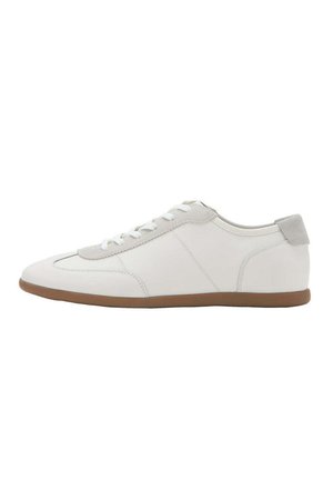 Zapatilla blanca de perfil bajo con cordones blancos, lengüeta de ante gris claro en el talón y suela plana marrón, mostrada desde el lado exterior.
