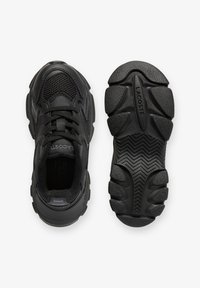 Black athletic sneakers featuring a mix of mesh and synthetic material, rounded toe, textured sole, and signature logo detail on the insole.