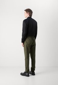 Tommy Jeans AUSTIN - Bukse - fatigue green