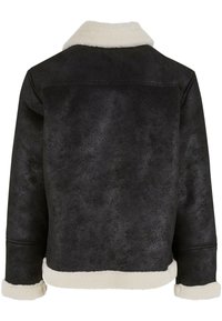 Chaqueta de borreguillo negra con un collar y puños de piel sintética, que presenta una superficie texturizada y una silueta corta. Sin cierres visibles.
