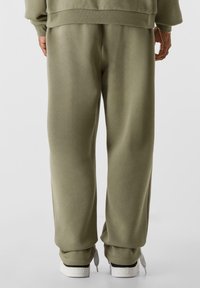 Olivgrüne Jogginghose mit lässiger Passform, aus weichem Stoff gefertigt, mit glatter Textur und elastischem Bund.