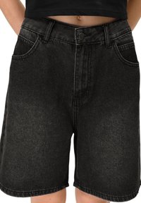 Shorts en denim noir à taille haute, avec une fermeture à bouton à l'avant, deux poches latérales et une coupe droite.