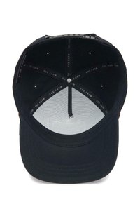 Black cap with a flat brim, featuring a textured fabric. Inside shows a smooth lining and a printed label pattern, with ventilation holes.