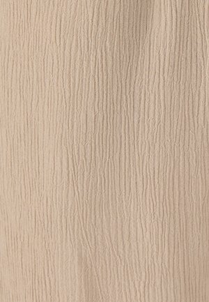 Tessuto beige con una sottile trama verticale a pieghe che crea motivi a coste morbide e irregolari su tutta la superficie.