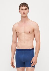 Herren Boxer-Shorts in Blau aus einem weichen, elastischen Stoff mit einer körperbetonten Passform. Breiter schwarzer Bund mit "BJÖRN BORG" Branding.