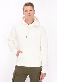 Creme hoodie lavet af blødt stof med en frontlomme og hætte med snor. Har en afslappet pasform og ribbede manchetter. Farven er lys og neutral.