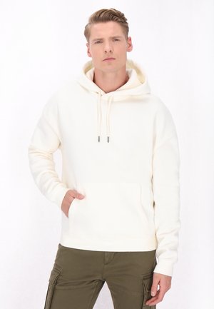 Creme hoodie lavet af blødt stof med en frontlomme og hætte med snor. Har en afslappet pasform og ribbede manchetter. Farven er lys og neutral.
