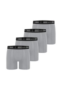 Quattro paia di boxer grigi con una vita nera, con il nome del marchio "nur die," esposti in fila.