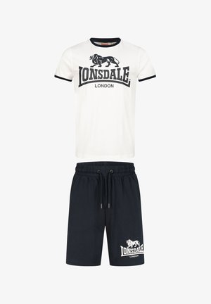 Camiseta blanca de algodón con ribetes negros, que presenta un logo de león y el texto "Lonsdale London"; combinada con pantalones cortos de un oscuro color marino con un logo similar.