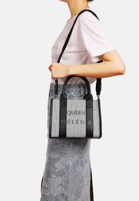 Borsa a tracolla nera e grigia con forma strutturata, caratterizzata dal testo "QUEEN HELENA", due manici superiori e una tracolla removibile.