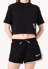 Svart kortärmad t-shirt med vit logotyp. Matchas med svarta shorts, vit dragsko och kontrastfärgade sidodetaljer.