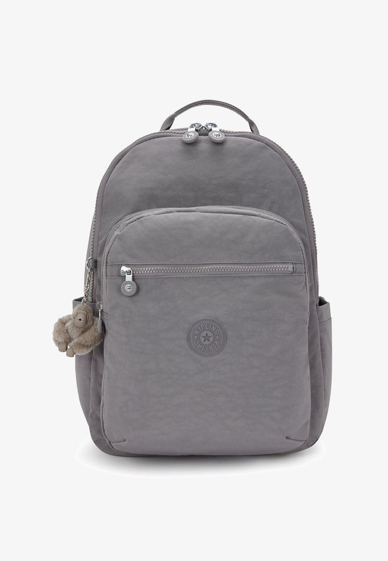 Szary plecak Kipling z przednią kieszenią na zamek błyskawiczny, bocznymi kieszeniami, uchwytem na górze oraz małym pluszowym breloczkiem w kształcie małpki.