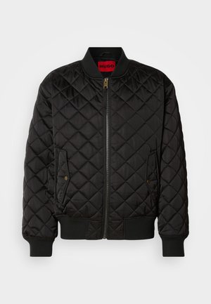 Sort quiltet bomberjakke med ribbet krave, manchetter og kant, lynlås foran og to klaplommer med trykknapper.