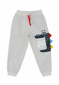 Graue Jogginghose mit einem schwarzen Dinosaurier-Print, rotem Kordelzug und bunten Schuppen. Weicher Stoff mit gerippten Bündchen und bedrucktem "RAWR"-Text.