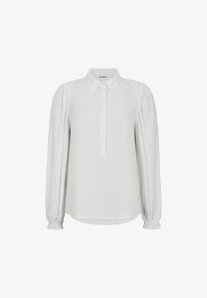 Vit blus med klassisk krage, knappslå och långa puffärmar med upptagna manschetter. Mjuk tyg och avslappnad passform.