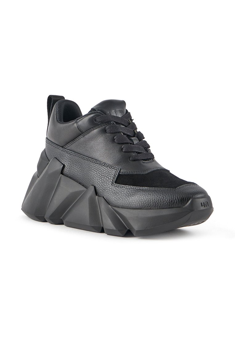 Czarne, masywne sneakersy z grubą, rzeźbioną podeszwą, wykonane z połączenia skórzanych tekstur i gładkich materiałów. Wyraźny design na sznurówki.