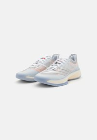 Light blue athletic shoes with mesh upper, textured accents, white laces, and a contrasting cream sole. Features streamlined design and rubber grip.