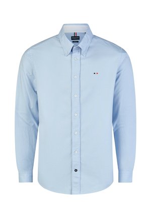 Hellblaues Hemd mit langen Ärmeln und Knöpfen, mit einem Button-Down-Kragen und einem kleinen rot-weiß-blauen Logo auf der linken Brustseite.