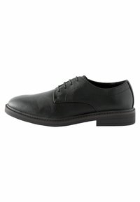 Zapato negro de cuero con cordones, de textura suave, punta redondeada y suela plana de goma. Presenta costuras sutiles a lo largo del borde.