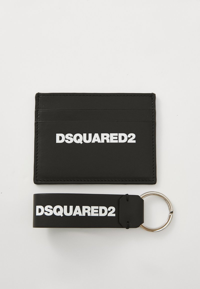 Black leather card holder with multiple slots, featuring a white "DSQUARED2" logo. Includes a matching black keychain with a silver ring.