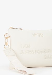 Borsa a sacchetto bianca con texture e testo in rilievo, "IO SONO UNA BORSA RESPONSABILE," e una tracolla staccabile con logo; hardware della cerniera in oro.
