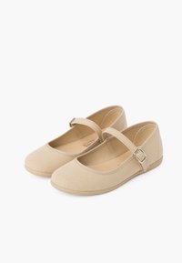 Bailarinas de lona beige con punta redonda, suela plana y una correa ajustable con hebilla plateada. Textura suave, diseño minimalista.