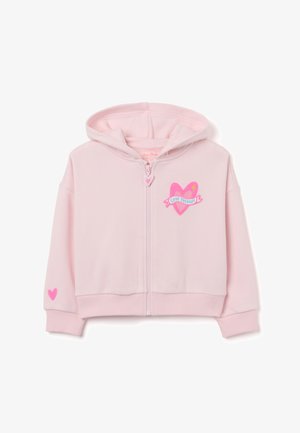Light pink zip-up hoodie featuring a heart design on the chest, with "Love Therapy" text and a small heart on one sleeve. Soft fabric.