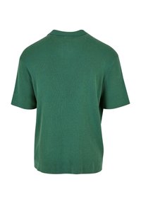 Grønn ribbestrikket genser med kort erm og rund hals. Myk tekstur, avslappet passform og sømløse skuldre. Minimalistisk design.
