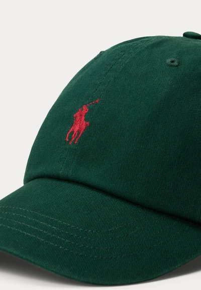 Zaļš kokvilnas beisbola cepure ar izliekta maliņu, uz priekšu izšūta sarkana logo un teksturēta auduma detaļas.