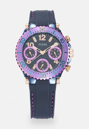 Guess wristwatch with black dial, iridescent purple bezel, three subdials, rose gold hands, and black strap with purple stitching.