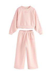 Różowy zestaw składający się z bawełnianej bluzy i szerokich spodni dresowych. Bluza ma ribbowany dekolt oraz wyszyty detal 'Baker'. Miękka tekstura w całej kolekcji.