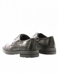 Scarpe in pelle nera con finitura liscia, punte arrotondate e suola in gomma bassa. Presentano cuciture sottili e un design con lacci.