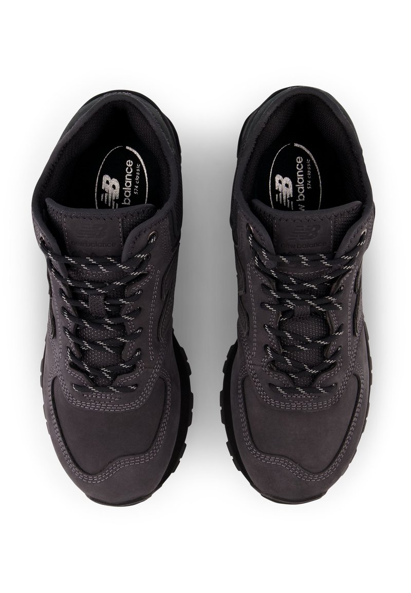 Czarne buty sportowe z gładką syntetyczną cholewką, wyściełanym kołnierzem, teksturowanymi sznurowadłami oraz gumową podeszwą z wyraźnym bieżnikiem.