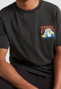 T-shirt in cotone nero con un design grafico colorato sul lato sinistro del petto, con il testo "O'NEILL" e un'illustrazione di onda. Maniche corte.