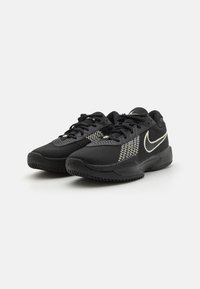 Svarte joggesko med mesh-overdel, teksturert detaljer og hvit Nike-swoosh-logo. Har snøring og gummisåler.