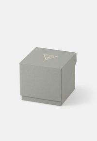 Graue, strukturierte Box mit einem goldenen, dreieckigen Logo. Quadratische Form mit einem schwenkbaren Deckel an der Oberseite, auf einem einfarbig weißen Hintergrund.