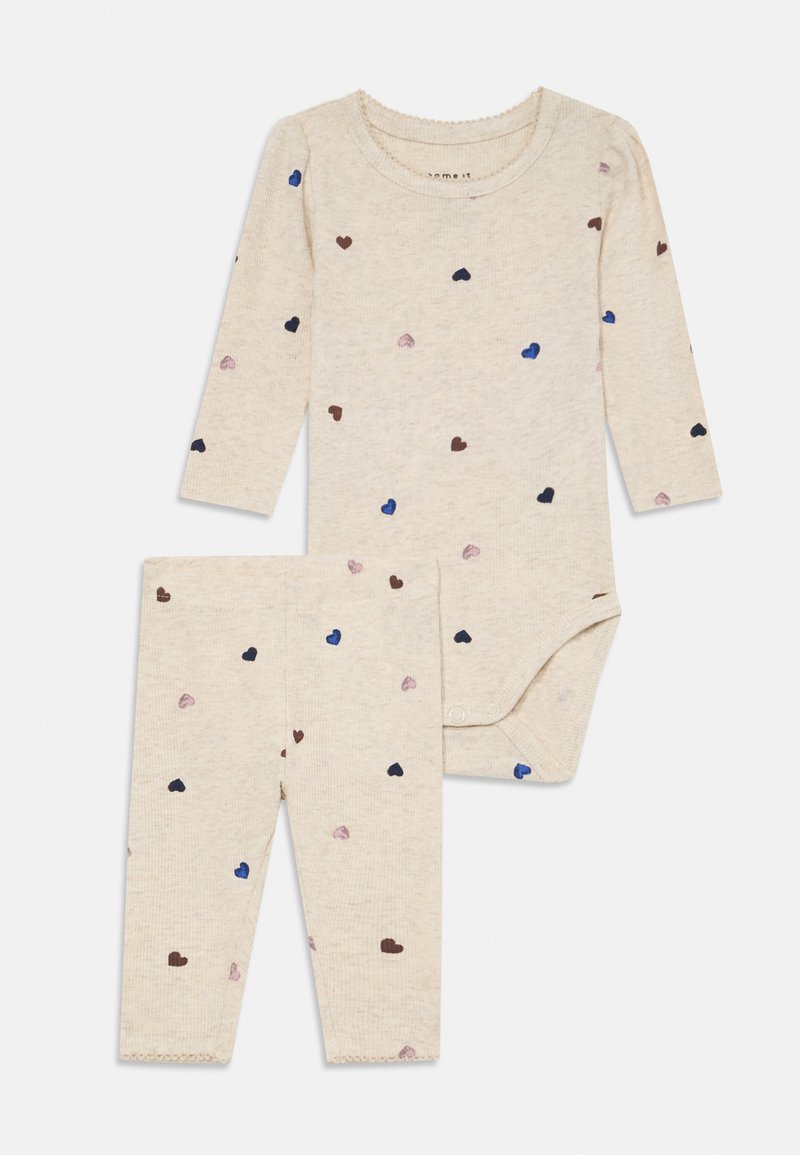 Beige pitkähihainen vauvan body ja siihen sopivat leggingsit, joissa on pieniä sinisiä, ruskeita ja vaaleanpunaisia sydänkuvioita.