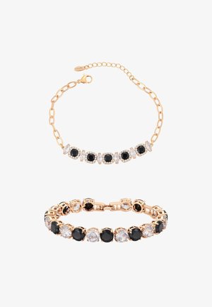 Dwie bransoletki w złotym odcieniu z naprzemiennymi czarnymi i przezroczystymi okrągłymi kamieniami szlachetnymi, jedna z ogniwami łańcuszka i zapięciem typu karabińczyk, druga z połączonymi oprawami.