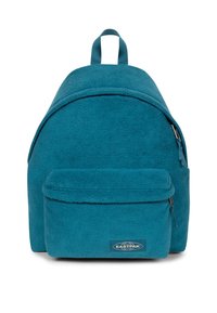 Mochila de forro polar en color verde azulado con forma redondeada, que incluye un bolsillo frontal con cremallera y una asa en la parte superior. Presenta una etiqueta de marca en la parte frontal.