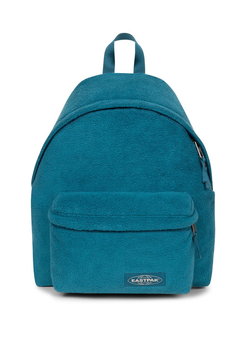 Mochila de forro polar en color verde azulado con forma redondeada, que incluye un bolsillo frontal con cremallera y una asa en la parte superior. Presenta una etiqueta de marca en la parte frontal.