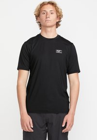 Czarny t-shirt z krótkim rękawem, wykonany z lekkiego materiału, z małym logo na lewej piersi. Gładka tekstura i klasyczny krój.
