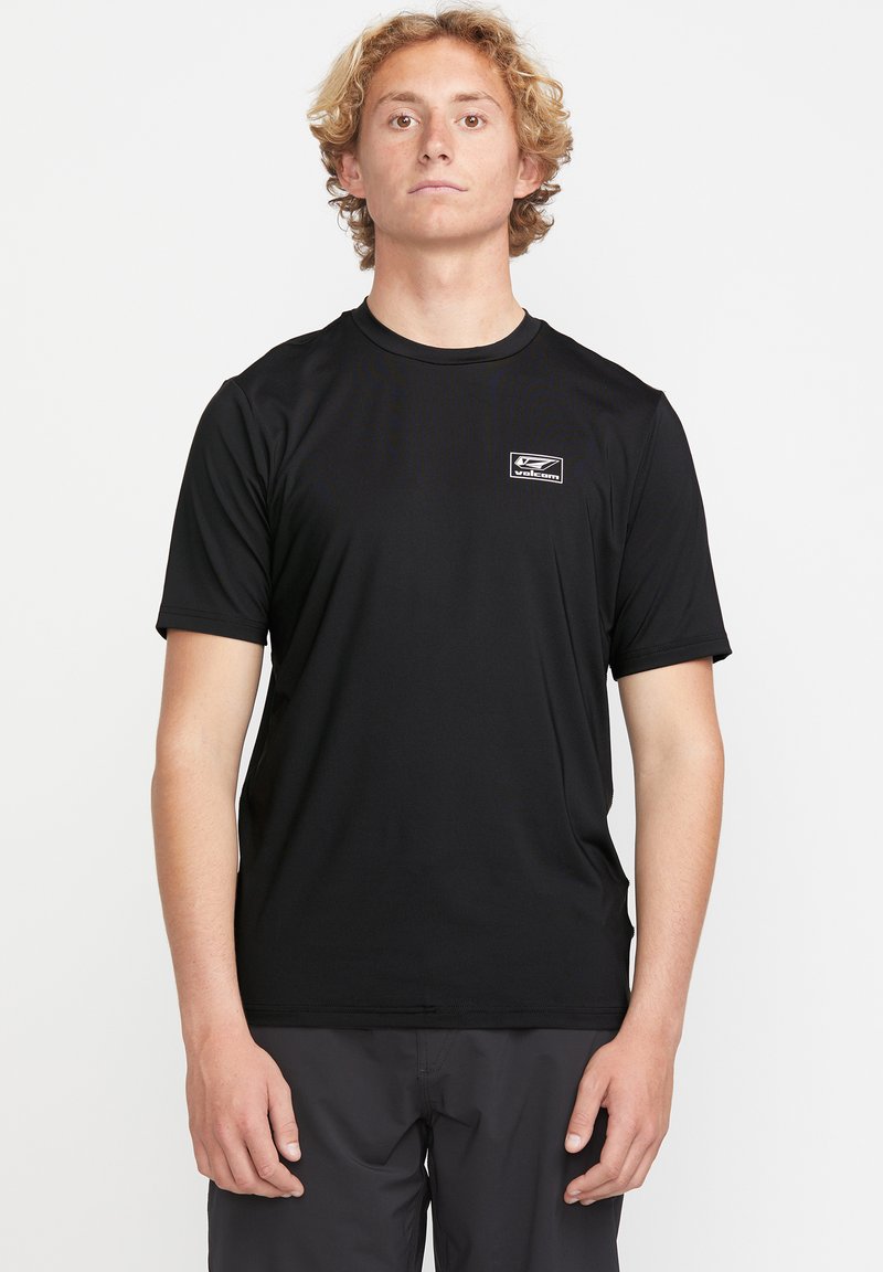 Czarny t-shirt z krótkim rękawem, wykonany z lekkiego materiału, z małym logo na lewej piersi. Gładka tekstura i klasyczny krój.