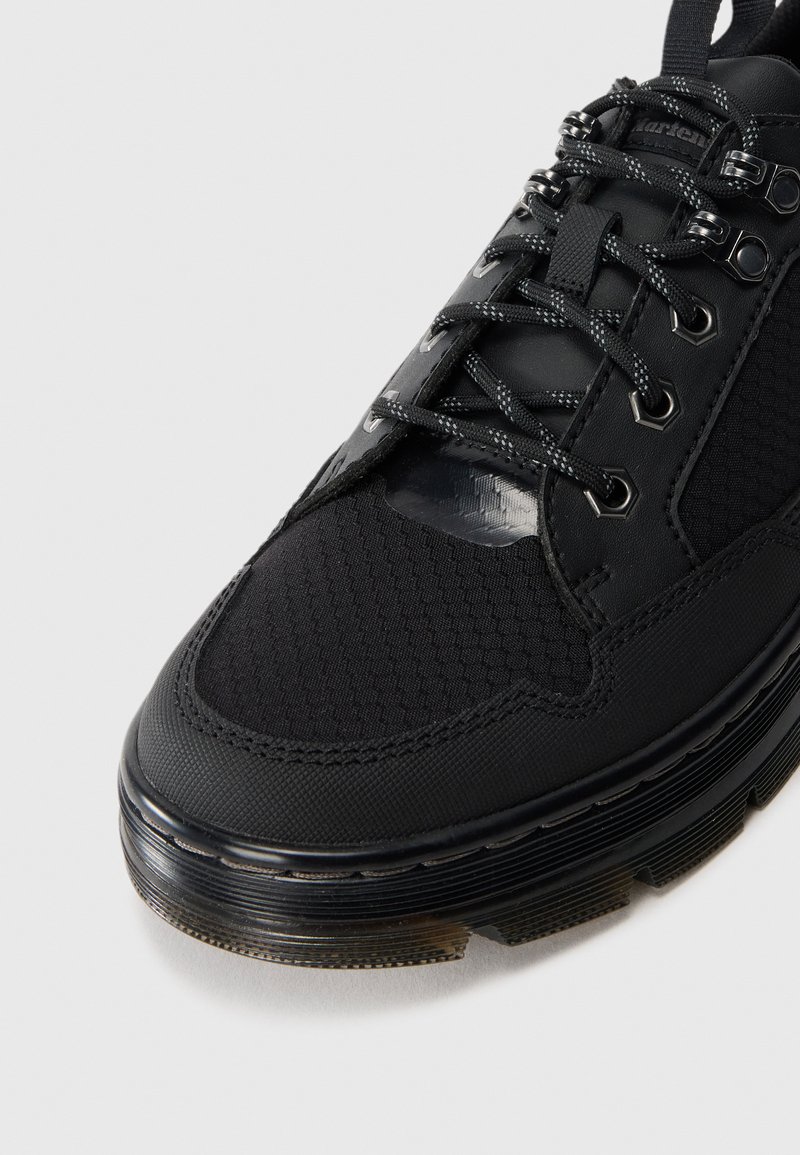 Botte noire à lacets avec tissu texturé et panneaux en cuir, œillets en métal, lacets réfléchissants et semelle en caoutchouc épaisse à rainures.