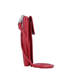 Sac bandoulière en cuir rouge avec un design vertical et élancé. Doté d'une sangle amovible et d'une base circulaire enroulée. Texture lisse et quincaillerie minimale.