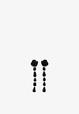 Pendientes florales negros con un diseño de rosa en la parte superior y formas de gota colgantes, todo en una textura de terciopelo y con acentos dorados.