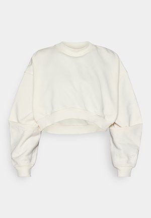 Beskjært sweatshirt i off-white stoff, med ribbestrikket rund hals, senkede skuldre og elastisk kant. Glatt tekstur og minimalistisk design.